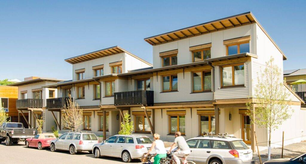 Bicyclists in front of portion of Ankeny Row co housing development in Portland, OR.