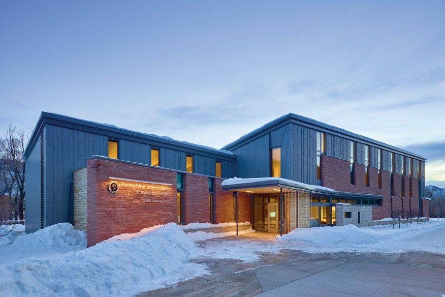 Front entrance of Rocky Mountain Innovation Center in Basalt, CO with piles of snow around building.