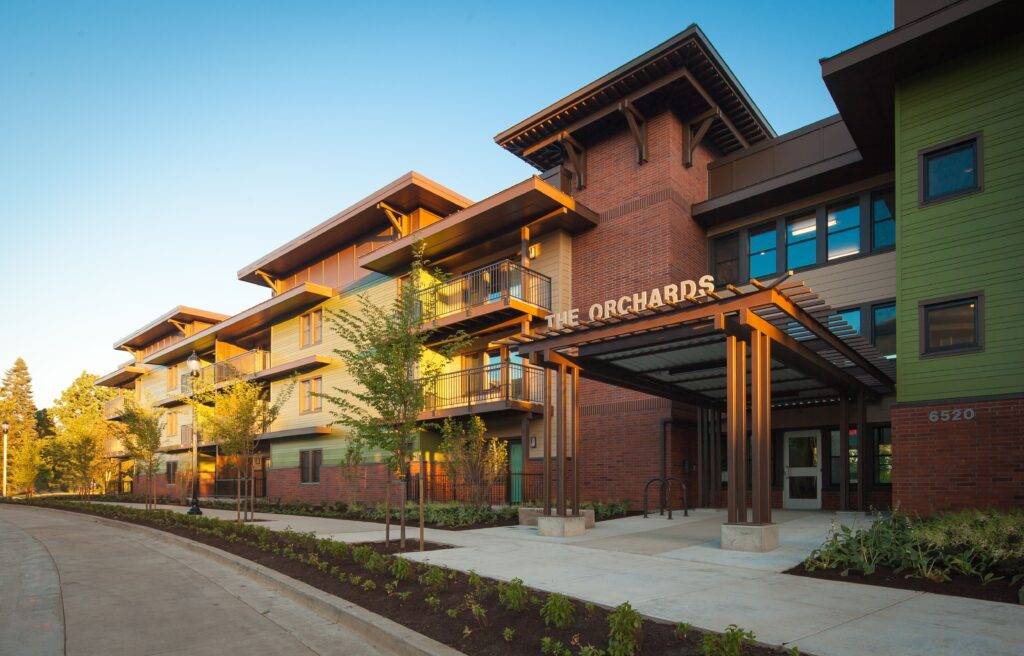 View of front entrance, sign, and sidewalk in front of The Orchards at Orenco Station in Hillsboro, Oregon.